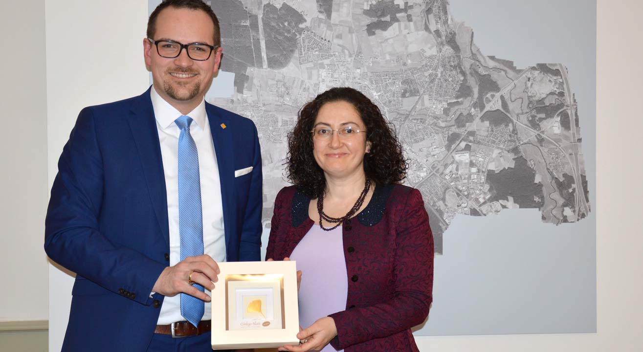 Die türkische Generalkonsulin Fatma Taşan Cebeci erhält als Geschenk ein vergoldetes Ginkgo-Blatt von Oberbürgermeister Peter Reiß überreicht..