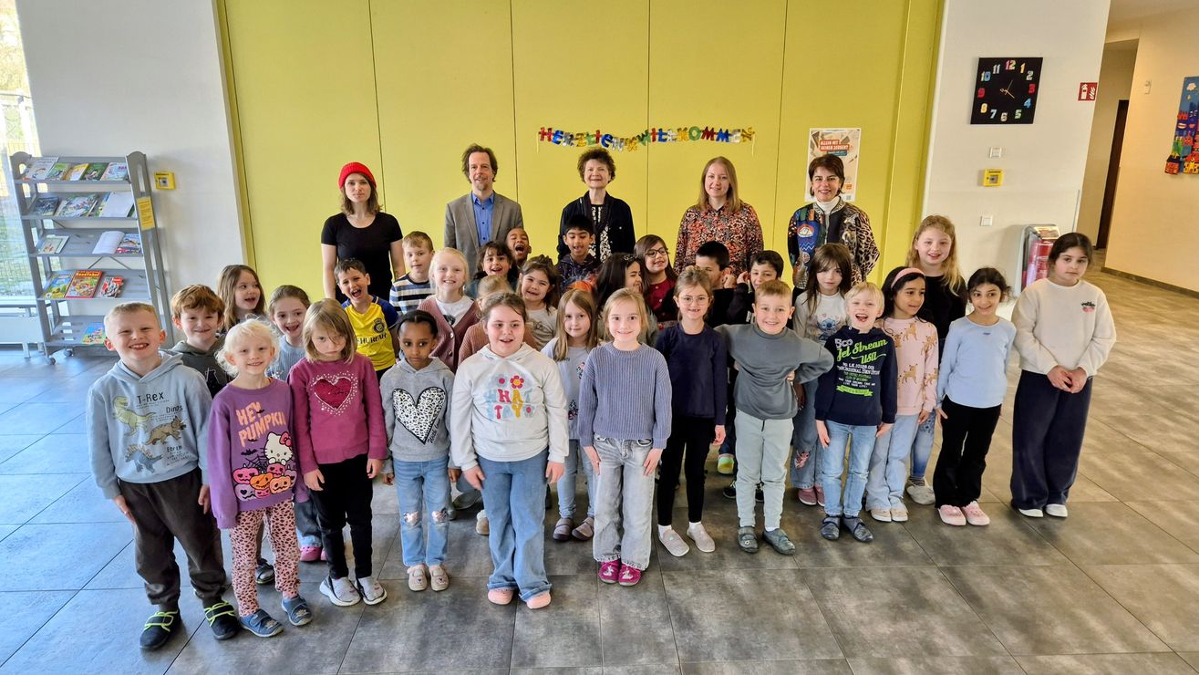 Schulklasse mit Lehrkraft, Musikschulleiter, Rektorin und Vorsitzenden des Förderverein für Integegrationsarbeit