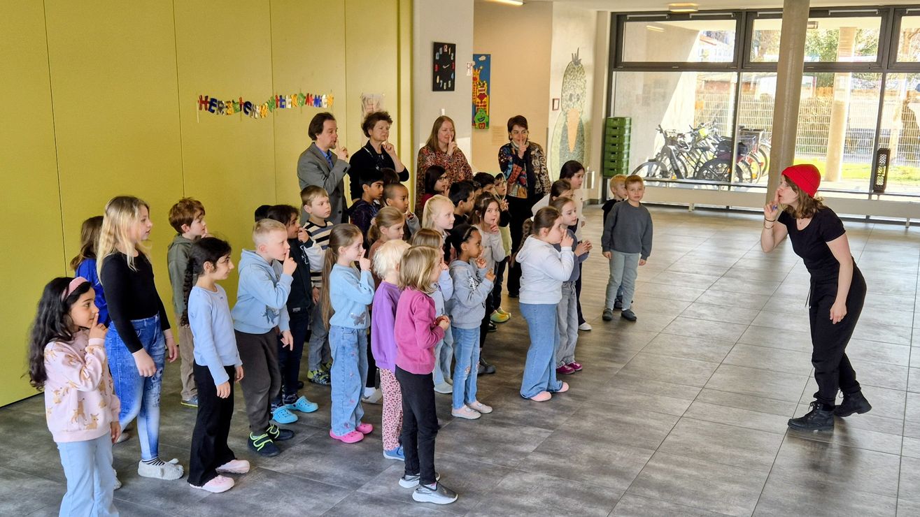 Lehrkraft singt mit Schüler:innen