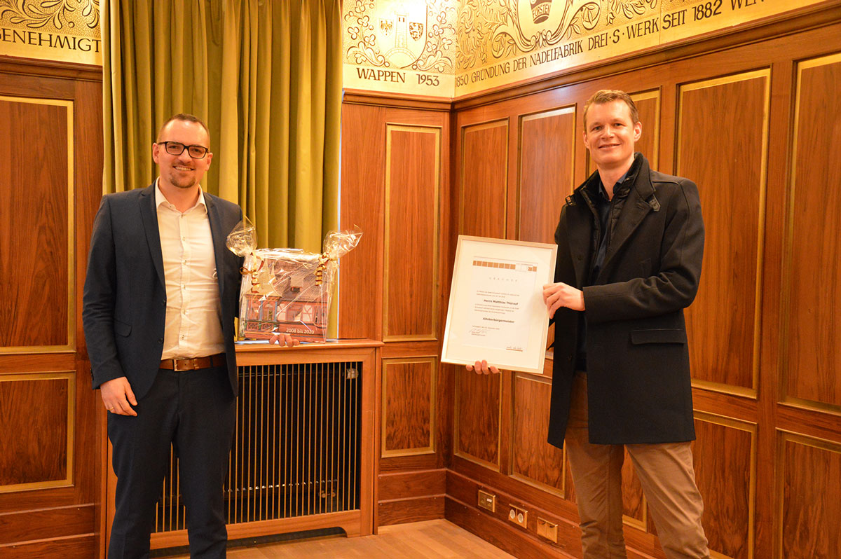 Peter Reiß überreicht dem neuen Altoberbürgermeister Matthias Thürauf die Ernennungsurkunde und ein Fotobuch mit Aufnahmen aus dessen Amtszeit.