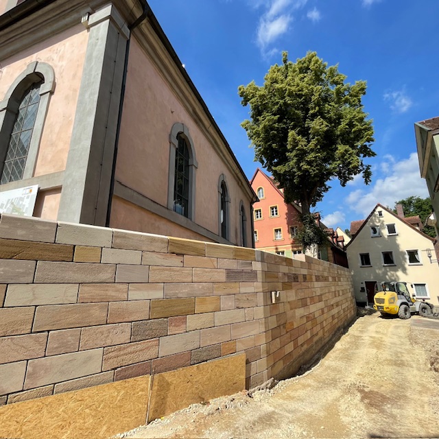 Kirche hinter einer Sandsteinmauer