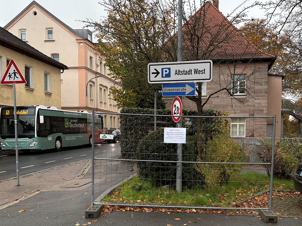 Absperrung mit Verkehrsschildern für Parkplatz Altstadt West, Einbahnstraße und 2,8 t Gewichtsbeschränkung vor Wohnhaus und Büschen an Straße mit Bus und parkendem Auto