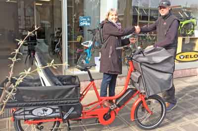 Eva Göttlein vom Quartiersmanagment beim Abholen des Lastenrads beim Fahrradhändler